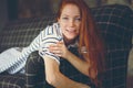 Portrait of young beautiful redhead woman relaxing at home in the autumn ot winter cozy evening