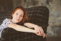 Portrait of young beautiful redhead woman relaxing at home in the autumn ot winter cozy evening Royalty Free Stock Photo