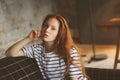 Portrait of young beautiful redhead woman relaxing at home in the autumn ot winter cozy evening Royalty Free Stock Photo