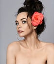 Portrait of young beautiful sexy brunette naked woman in circle earrings with rose in hair