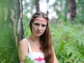 Portrait of a young beautiful Slavic girl with long hair and Slavic ethnic dress in a summer forest Royalty Free Stock Photo