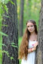 Portrait of a young beautiful Slavic girl with long hair and Slavic ethnic dress in a summer forest Royalty Free Stock Photo