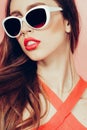 Portrait of young beautiful slim woman in sexy dress with sensual lips in studio wearing sunglasses. smiling and posing Royalty Free Stock Photo