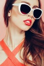 Portrait of young beautiful slim woman in sexy dress with sensual lips in studio wearing sunglasses. smiling and posing Royalty Free Stock Photo