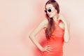 Portrait of young beautiful slim woman in sexy dress with sensual lips in studio wearing sunglasses. smiling and posing Royalty Free Stock Photo