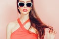 Portrait of young beautiful slim woman in sexy dress with sensual lips in studio wearing sunglasses. smiling and posing Royalty Free Stock Photo