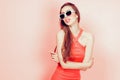 Portrait of young beautiful slim woman in sexy dress with sensual lips in studio wearing sunglasses. smiling and posing Royalty Free Stock Photo