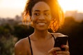 Young beautiful smiling curly african woman with phone looking aside Royalty Free Stock Photo