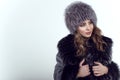 Portrait of young beautiful smiling model wearing trendy knit fox fur hat and coat Royalty Free Stock Photo