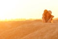 Portrait of young beautiful smiling woman with long hair with straw hat on head lying on sand at sunrise in sandy desert Royalty Free Stock Photo
