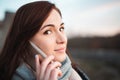 Portrait of young beautiful smilling woman with big eyes calling with cell telephone - captured from side profile. Brunette
