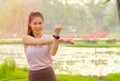 Portrait of young beautiful sport girl action of arms stretched in the garden or park with morning light