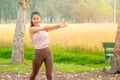 Portrait of young beautiful sport girl action of arms stretched in the garden or park with morning light