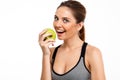 Portrait of young beautiful sportive girl holding apple over white background. Royalty Free Stock Photo