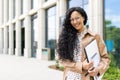 Portrait of young beautiful successful business woman outside office building, successful Latin American woman smiling Royalty Free Stock Photo