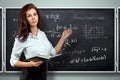 Portrait of a young beautiful teacher on the background of the school blackboard. Teacher`s Day Knowledge Day back to school stud Royalty Free Stock Photo