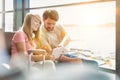 Portrait of young beautiful teenage girl showing digital tablet to her father while sitting and waiting for their flight in Royalty Free Stock Photo