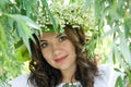 Portrait of a young beautiful in traditional Ukrainian embroidered shirt and a wreath of lilies of the valley