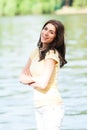 Portrait of young beautiful woman against lake in summer city park. Royalty Free Stock Photo
