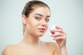 Portrait of young beautiful woman applying moisturizing cream on her face Royalty Free Stock Photo