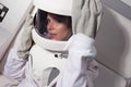 Portrait of a young beautiful woman astronaut, close-up. The woman in the suit screams