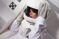 Portrait of a young beautiful woman astronaut, close-up. The woman in the suit screams