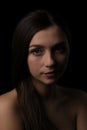 Portrait of young beautiful woman on black background. How to photograph a female portrait in a low key. Royalty Free Stock Photo