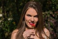 Portrait of young and beautiful woman, blonde, blue eyes, smelling a red flower that she holds in her hands. Concept beauty, Royalty Free Stock Photo