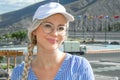 Portrait of a young beautiful woman, blonde in a cap, glasses and with a scythe.