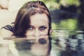 Portrait of young beautiful woman with blue eyes lying in the clear river water in summer. Concept Wellness, Advertising Royalty Free Stock Photo