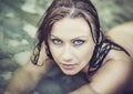 Portrait of young beautiful woman with blue eyes lying in the clear river water in summer. Concept Wellness, Advertising Royalty Free Stock Photo