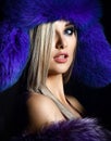 Portrait of young beautiful woman in blue purple fashion arctic fox winter fur ear flap hat Royalty Free Stock Photo