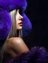 Portrait of young beautiful woman in blue purple fashion arctic fox winter fur ear flap hat Royalty Free Stock Photo