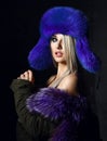 Portrait of young beautiful woman in blue purple fashion arctic fox winter fur ear flap hat Royalty Free Stock Photo