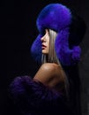 Portrait of young beautiful woman in blue purple fashion arctic fox winter fur ear flap hat Royalty Free Stock Photo