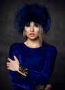 Portrait of young beautiful woman in blue purple fashion arctic fox winter fur ear flap hat Royalty Free Stock Photo