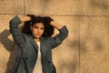 Portrait of young and beautiful woman, brunette, with curly hair, jacket with hands in her hair and seductive look. Concept beauty Royalty Free Stock Photo