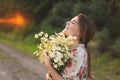 Portrait young beautiful woman with chamomile flowers at sunset. Royalty Free Stock Photo