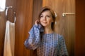 Portrait of Young Beautiful Woman in Dress Doing Make-up Standing Near Mirror Royalty Free Stock Photo