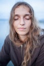 Portrait of a young beautiful woman of European appearance with long blond hair with closed eyes Royalty Free Stock Photo