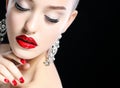 Portrait of young beautiful woman with evening make up touching her face over black background. Red lips and nails. Royalty Free Stock Photo