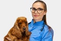 Portrait of young beautiful woman, female veterinary, vet doctor holding cute brown spaniel dog isolated over white Royalty Free Stock Photo