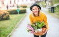 Young woman with flowers in a basket in sunny spring town. Royalty Free Stock Photo