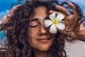 Portrait of young and beautiful cheerful woman with frangipani flower on the beach Royalty Free Stock Photo