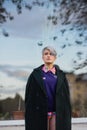 Portrait of a young beautiful woman in green coat with a short haircut and dyed hair. Grey main color and yellow, green Royalty Free Stock Photo