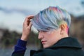 Portrait of a young beautiful woman in green coat with a short haircut and dyed hair. Grey main color and yellow, green Royalty Free Stock Photo