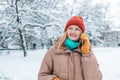 Happy young lady having mobile phone conversation on Xmas eve outdoors in winter time. Millennial woman calling on Royalty Free Stock Photo