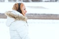 Portrait of a young beautiful woman with headphones outdoors in winter. Woman walking in mountains Royalty Free Stock Photo