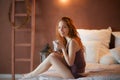 Portrait of young beautiful woman her hands holding cup of coffee morning cold winter time in her white bedroom. Happy Royalty Free Stock Photo