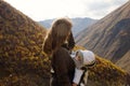 Portrait of young beautiful woman with her little sleeping daughter in ergo carrier on a background of autumn mountains. Royalty Free Stock Photo